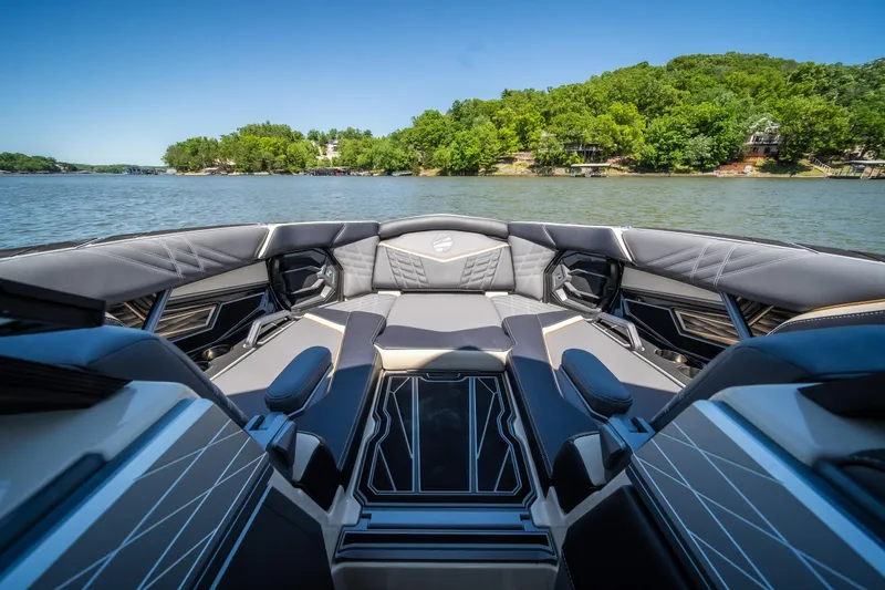 Slide: The Image of 2025 Tigé Ultré 23ZX boat interior with luxurious seating on a scenic lake. - 22