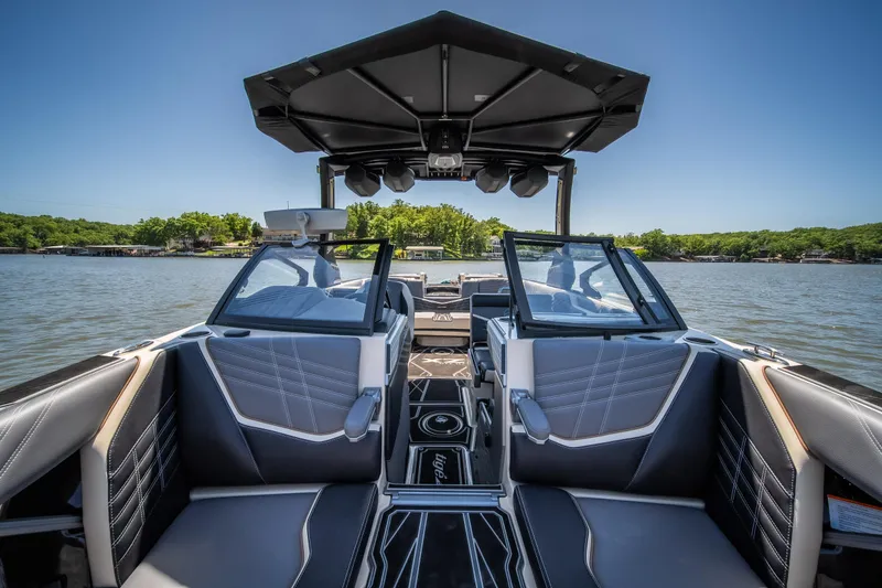 Slide: The Image of 2025 Tigé Ultré 23ZX boat interior with sleek seating and modern design on a sunny lake. - 24