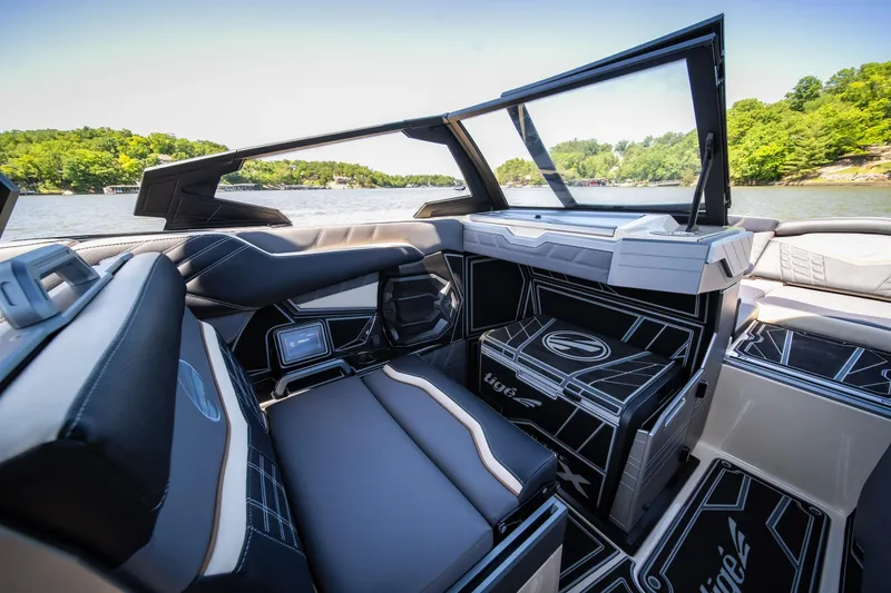Slide: The Image of 2025 Tigé Ultré 23ZX boat interior with sleek seating and modern design on a scenic lake. - 30