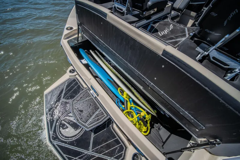 Slide: The Image of 2025 Tigé Ultré 23ZX boat with open storage compartment, revealing water sports equipment. - 36