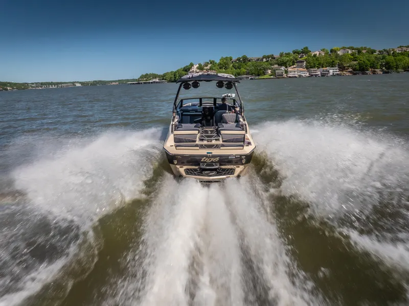 Slide: The Image of 2025 Tigé Ultré 23ZX boat cruising on a lake, creating a dynamic wake. - 4
