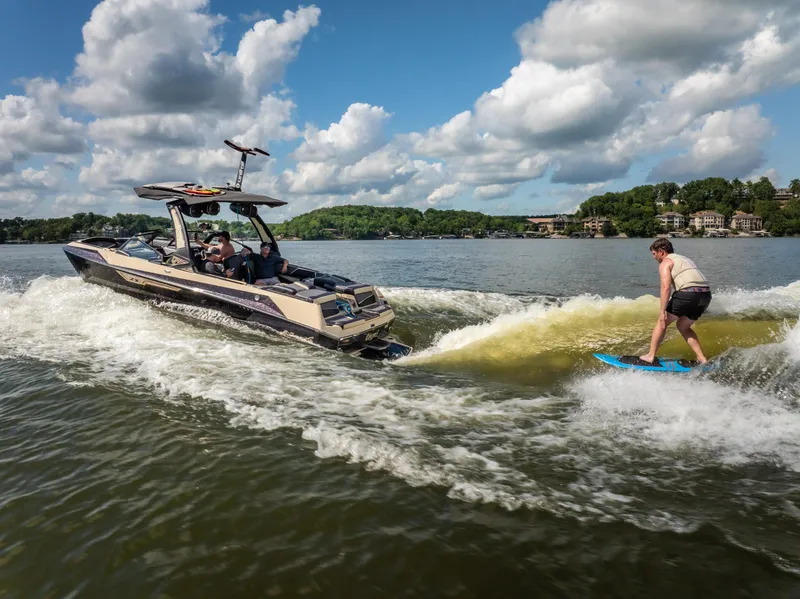 Slide: The Image of 2025 Tigé Ultré 23ZX boat creating waves for wakesurfing on a sunny lake. - 7