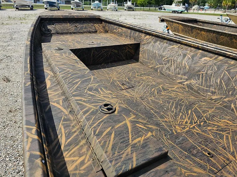 Slide: The Image of 2025 G3 Gator Tough 15 DK boat with camouflage design, parked on gravel. - 14