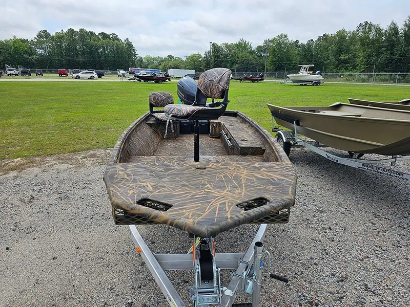 Slide: The Image of 2025 G3 Gator Tough 15 DK boat on trailer, camo design, parked outdoors. - 3