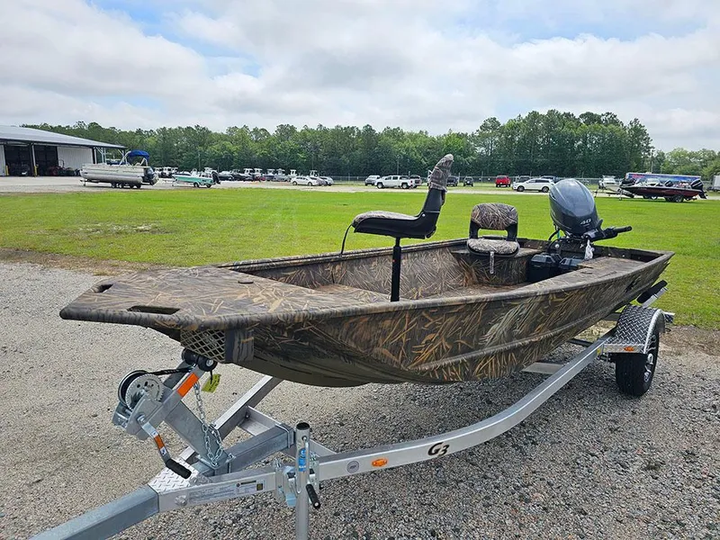 Slide: The Image of 2025 G3 Gator Tough 15 DK boat on trailer, camo design, parked outdoors. - 4