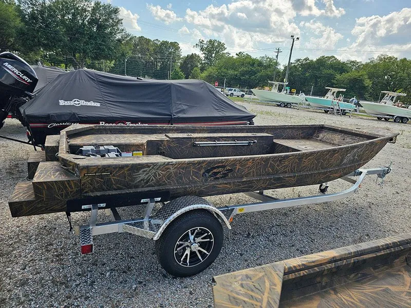 Slide: The Image of 2025 G3 Gator Tough 15 DK boat on trailer, camo design, parked outdoors. - 6