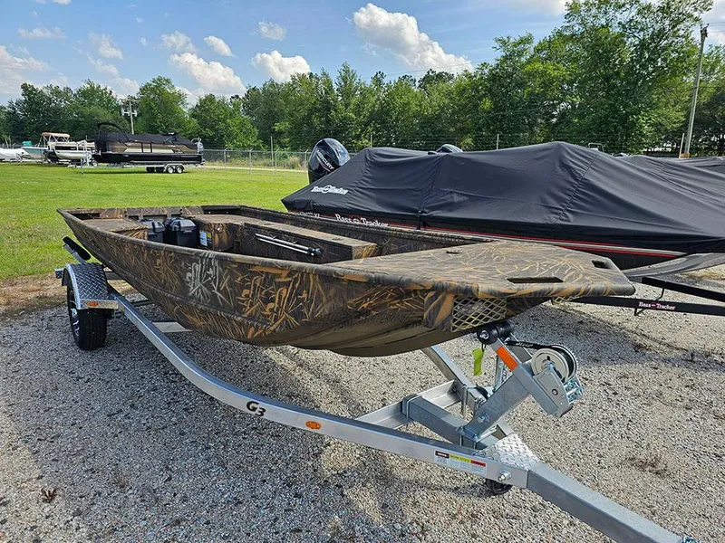 Slide: The Image of 2025 G3 Gator Tough 15 DK boat on trailer, camo design, parked outdoors. - 7