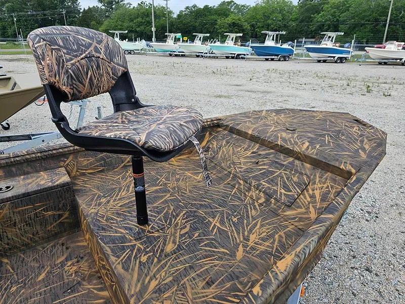 Slide: The Image of 2025 G3 Gator Tough 15 DK boat with camo seat and deck, parked outdoors. - 9