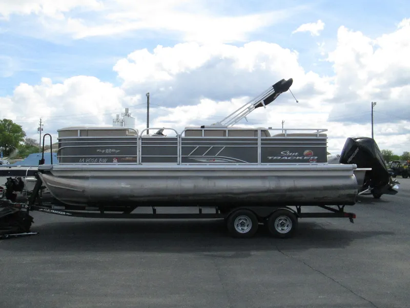 Slide: The Image of 2023 Sun Tracker PARTY BARGE 22RF XP3 pontoon boat on trailer, under cloudy sky. - 4