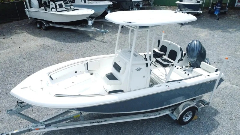 Slide: The Image of 2025 Tidewater 198 CC Adventure boat on trailer, white and gray, outdoor display. - 2