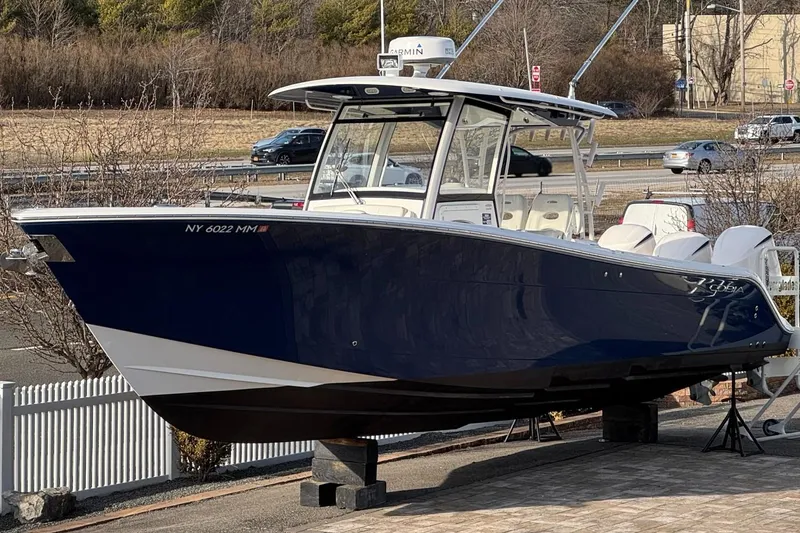 Slide: The Image of 2017 Cobia 344 Center Console boat displayed on a stand outdoors. - 1