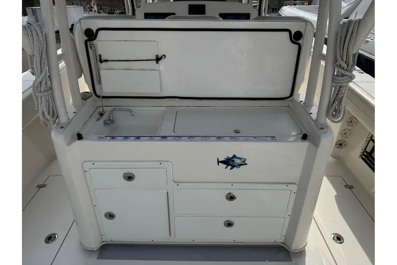 Slide: The Image of 2017 Cobia 344 Center Console boat interior with sink and storage compartments. - 12