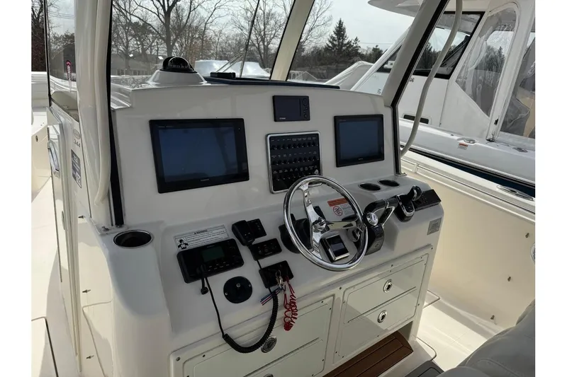 Slide: The Image of 2017 Cobia 344 Center Console helm with modern navigation equipment and steering wheel. - 7