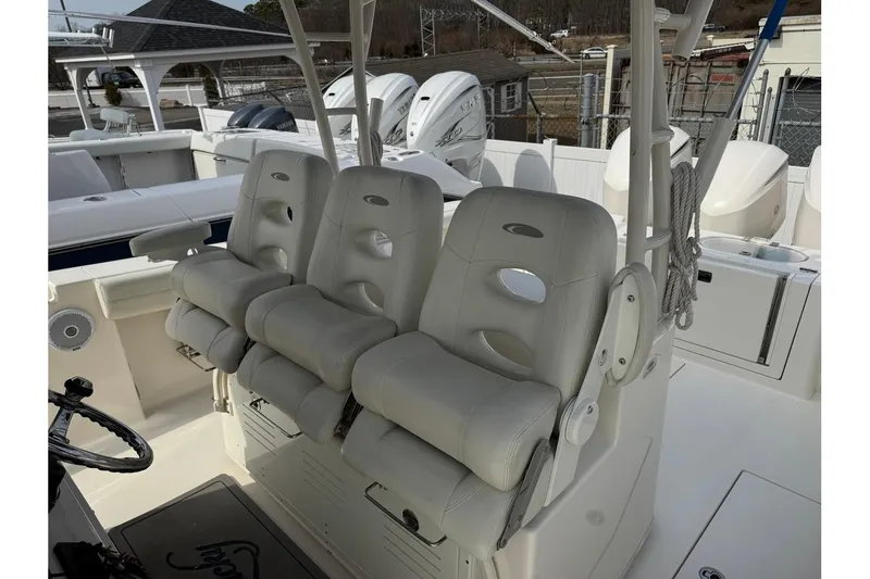 Slide: The Image of 2017 Cobia 344 Center Console boat with three cushioned seats and steering wheel. - 9