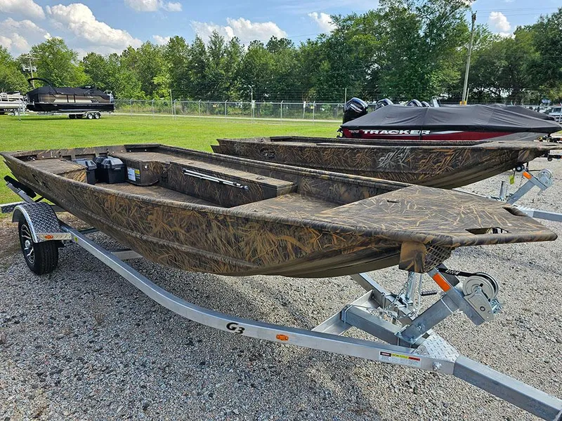 Slide: The Image of 2025 G3 Gator Tough 15 DK boat on trailer, camo design, parked outdoors. - 10