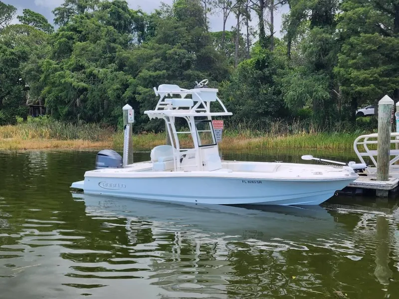 Slide: The Image of 2020 Robalo 246 Cayman boat docked on a calm lake with lush greenery. - 16