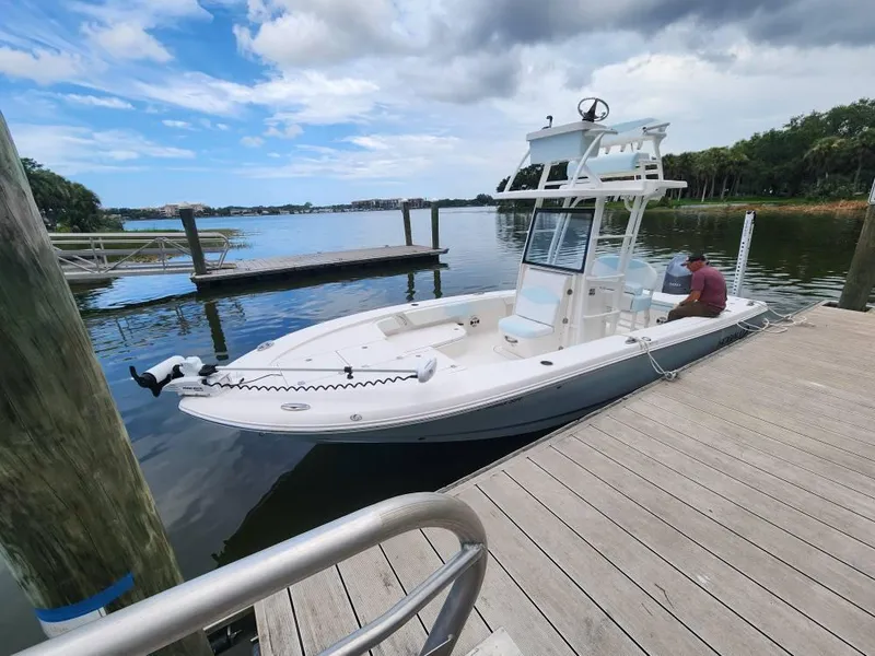 Slide: The Image of 2020 Robalo 246 Cayman boat docked on a calm lake under a cloudy sky. - 17