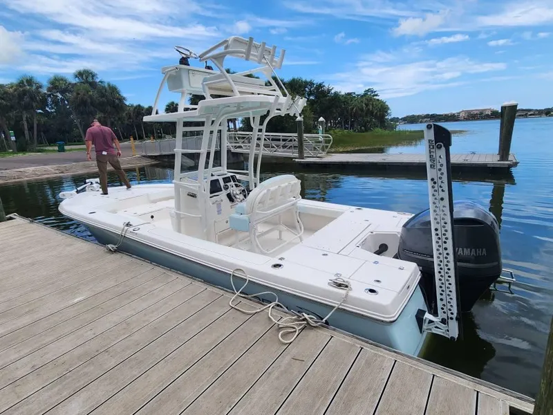 Slide: The Image of 2020 Robalo 246 Cayman boat docked by a serene lake with a Yamaha engine. - 19
