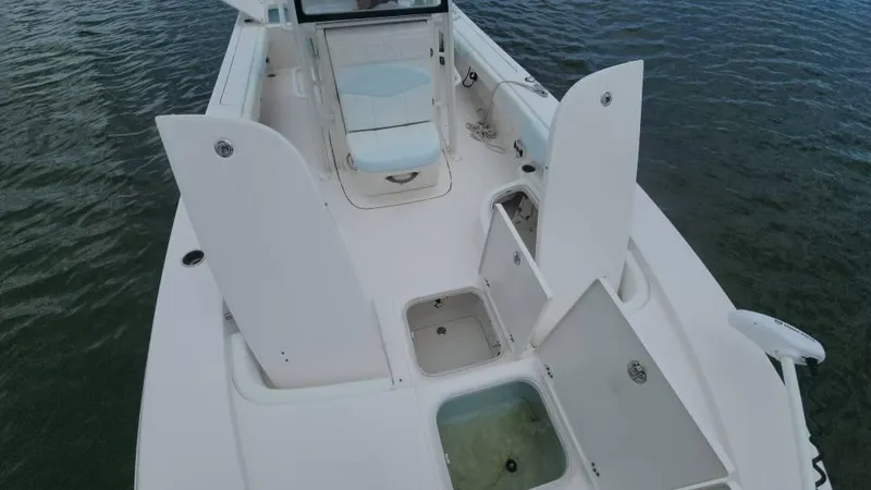 Slide: The Image of 2020 Robalo 246 Cayman boat interior with open storage compartments on the water. - 22