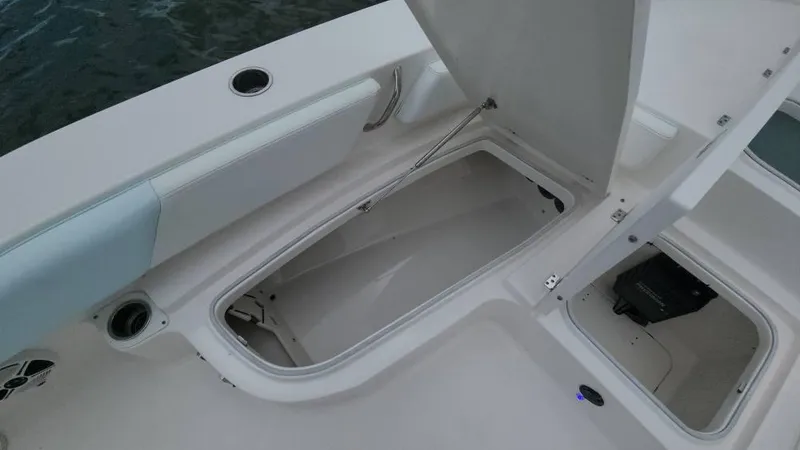 Slide: The Image of 2020 Robalo 246 Cayman boat storage compartments open on deck. - 25