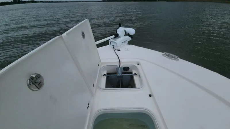 Slide: The Image of 2020 Robalo 246 Cayman boat with open storage compartments on calm water. - 31