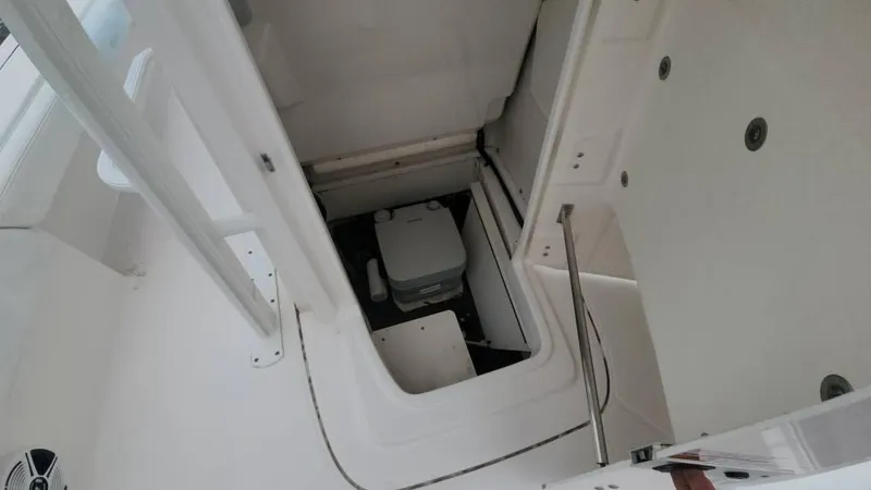 Slide: The Image of 2020 Robalo 246 Cayman boat storage compartment with portable toilet. - 32