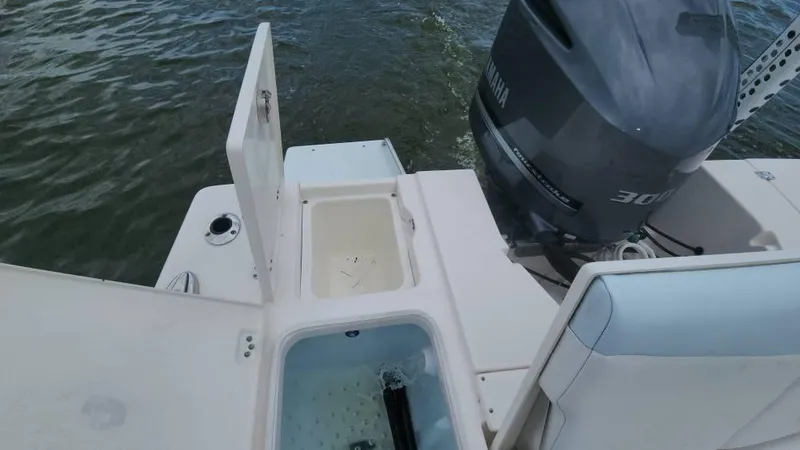 Slide: The Image of 2020 Robalo 246 Cayman boat with Yamaha engine, open storage compartments, on water. - 36