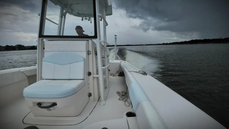 Slide: The Image of 2020 Robalo 246 Cayman boat cruising on a lake under cloudy skies. - 4
