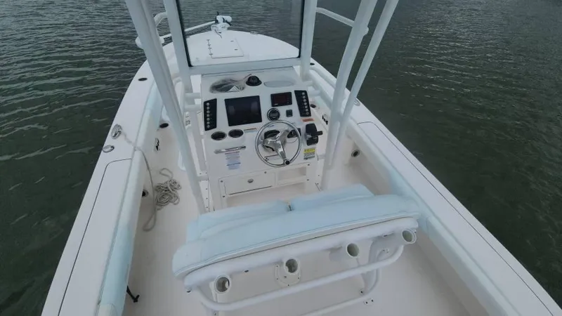 Slide: The Image of 2020 Robalo 246 Cayman boat interior with steering console on calm water. - 44