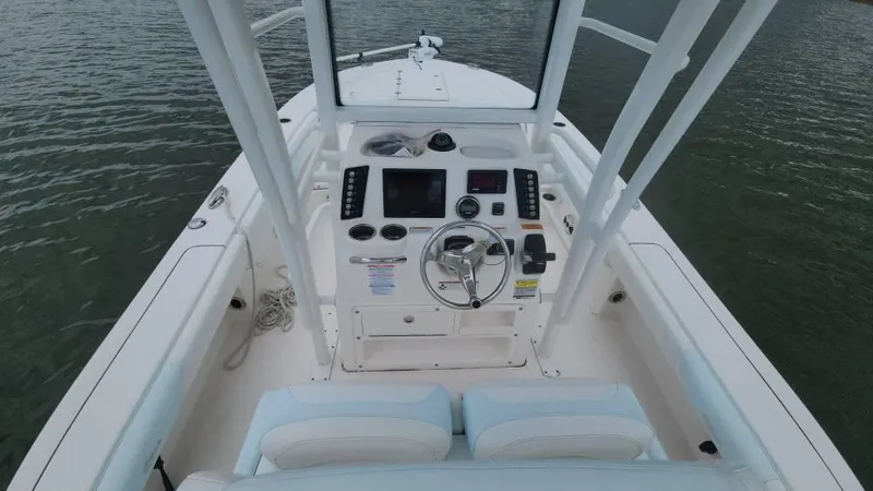 Slide: The Image of 2020 Robalo 246 Cayman boat interior with steering console on calm water. - 45