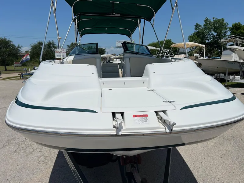 Slide: The Image of 2000 Chris-Craft 260DB boat with green canopy, viewed from the rear on a trailer. - 1