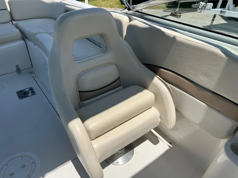 Slide: The Image of Captain's seat on 2000 Chris-Craft 260DB boat, featuring beige upholstery and sleek design. - 14