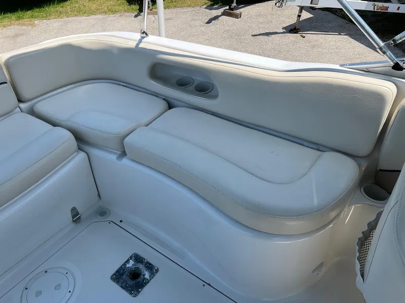 Slide: The Image of Cream-colored seating on a 2000 Chris-Craft 260DB boat, featuring cup holders. - 18