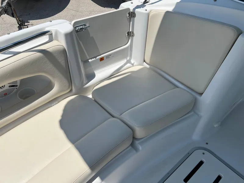 Slide: The Image of 2000 Chris-Craft 260DB boat interior with beige seating and storage compartment. - 21
