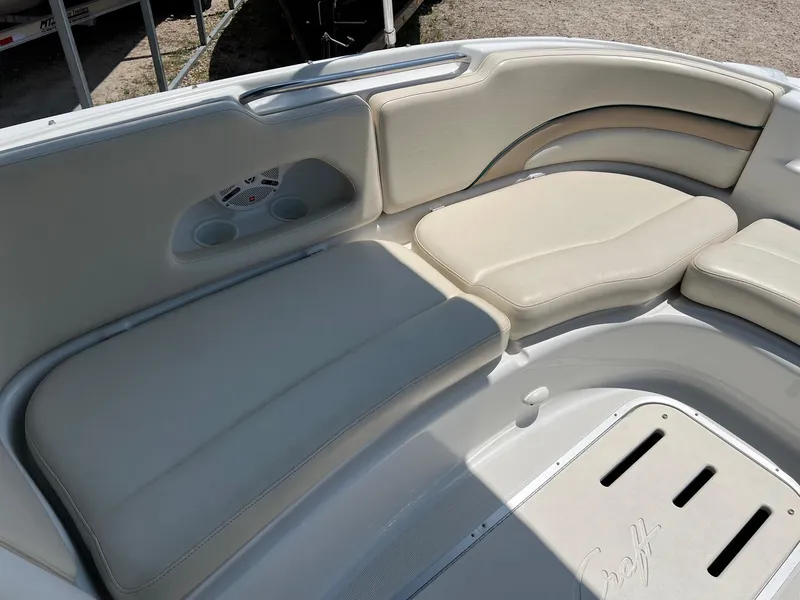 Slide: The Image of Luxurious seating on 2000 Chris-Craft 260DB boat with beige upholstery and cup holders. - 23