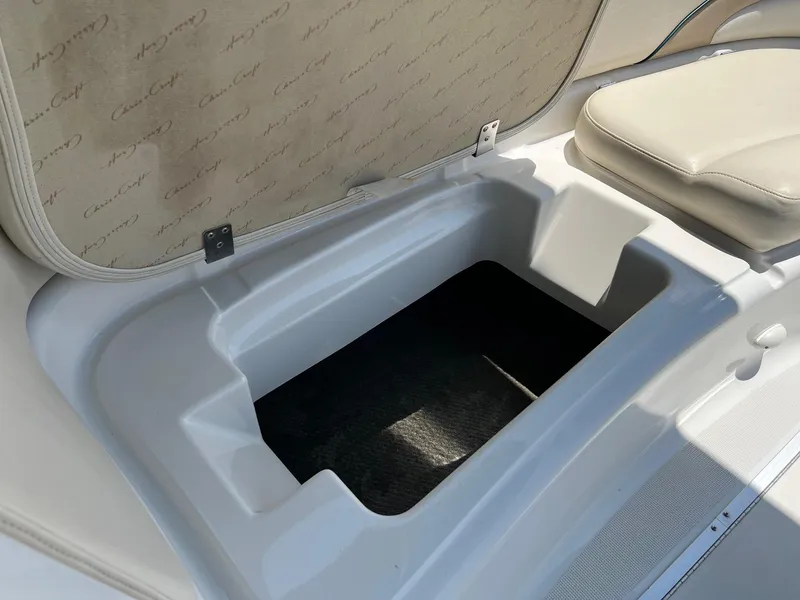 Slide: The Image of Open storage compartment in a 2000 Chris-Craft 260DB boat, featuring beige interior. - 24