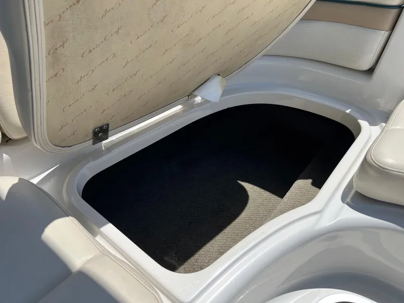 Slide: The Image of Open storage compartment on a 2000 Chris-Craft 260DB boat, featuring beige upholstery. - 25