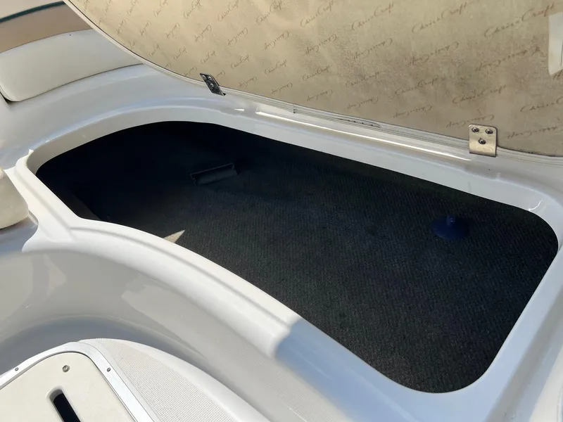 Slide: The Image of Open storage compartment in 2000 Chris-Craft 260DB boat, featuring carpeted interior. - 26