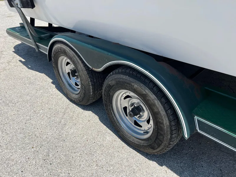 Slide: The Image of Trailer wheels of a 2000 Chris-Craft 260DB boat on pavement. - 33