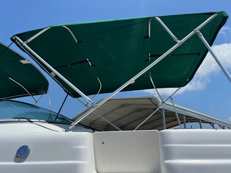 Slide: The Image of Chris-Craft 260DB 2000 boat with green canopy under blue sky. - 5