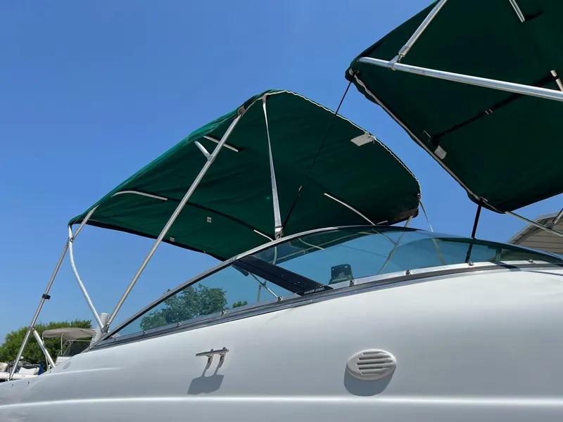 Slide: The Image of Chris-Craft 260DB 2000 boat with green canopy under clear blue sky. - 6