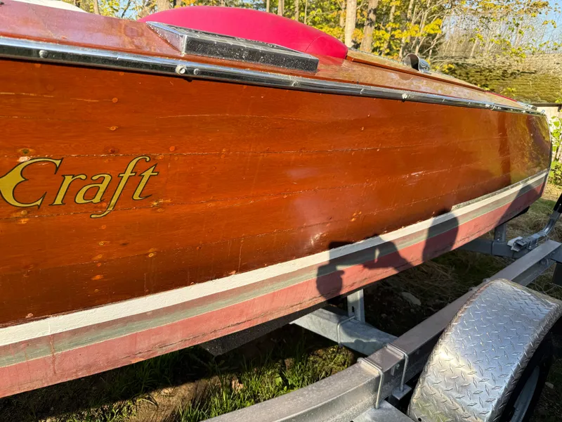 Slide: The Image of 1932 Chris-Craft 301 wooden boat on trailer, showcasing polished wood finish. - 4