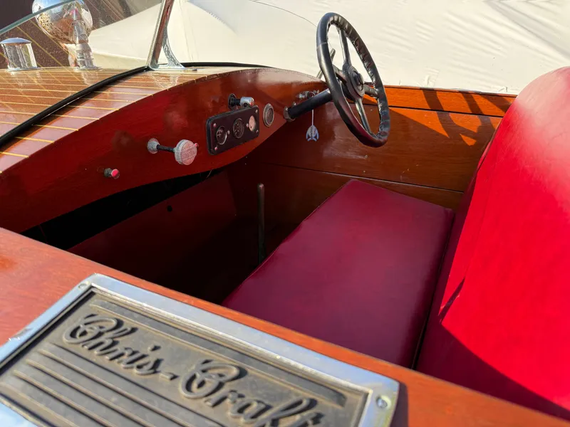 Slide: The Image of 1932 Chris-Craft 301 boat interior with red seating and wooden dashboard. - 6