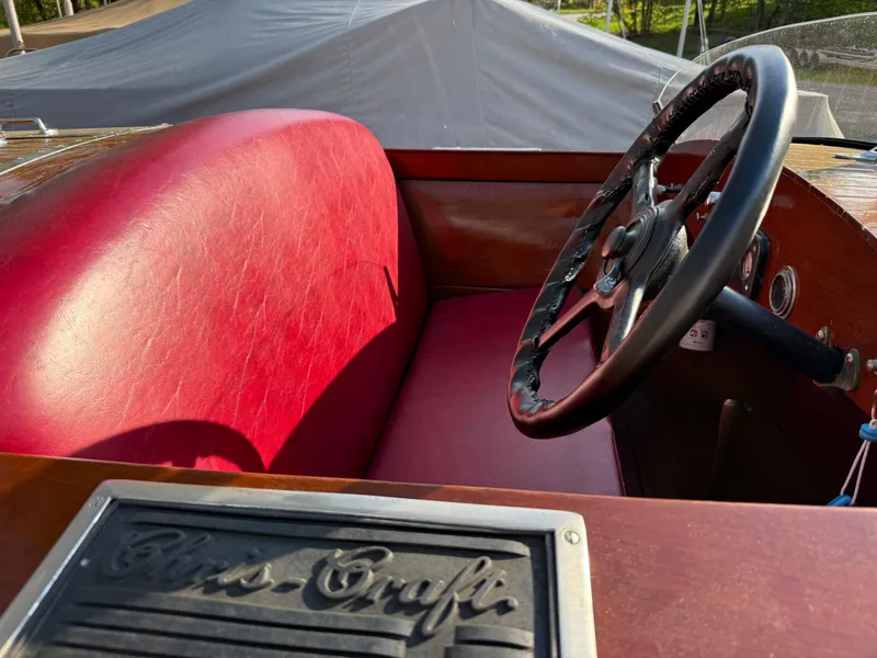 Slide: The Image of 1932 Chris-Craft 301 boat interior with red leather seat and vintage steering wheel. - 7
