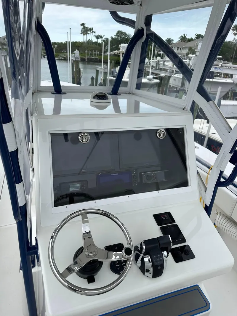 Slide: The Image of 2013 SeaHunter 35 Tournament boat helm with steering wheel and controls, docked at marina. - 11