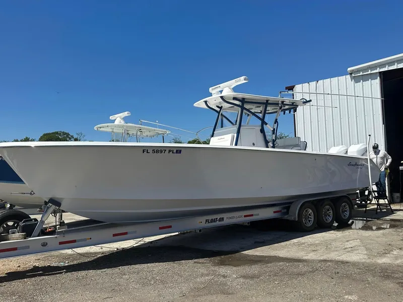 Slide: The Image of 2013 SeaHunter 35 Tournament boat on trailer, parked outdoors under clear blue sky. - 24