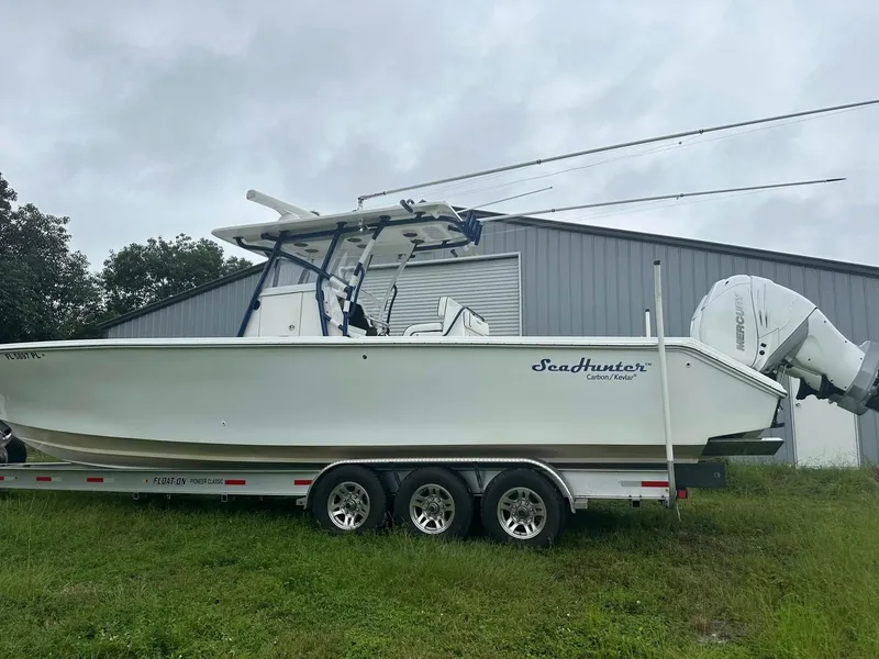 Slide: The Image of 2013 SeaHunter 35 Tournament boat on trailer, parked on grass, overcast sky. - 30
