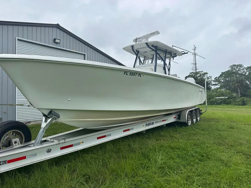 Slide: The Image of 2013 SeaHunter 35 Tournament boat on trailer near metal building, grassy area. - 33