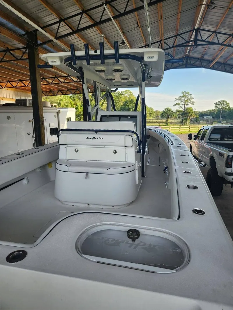 Slide: The Image of 2013 SeaHunter 35 Tournament boat in covered storage, showcasing spacious deck and seating. - 5