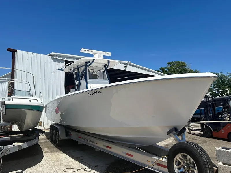 Slide: The Image of 2013 SeaHunter 35 Tournament boat on trailer, parked outdoors near a metal building. - 7